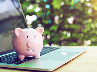 piggy bank sitting on laptop